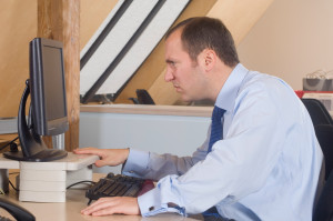 Sitting in office in front of computer