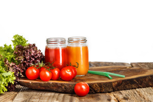 The bottles with fresh vegetable juices on wooden table