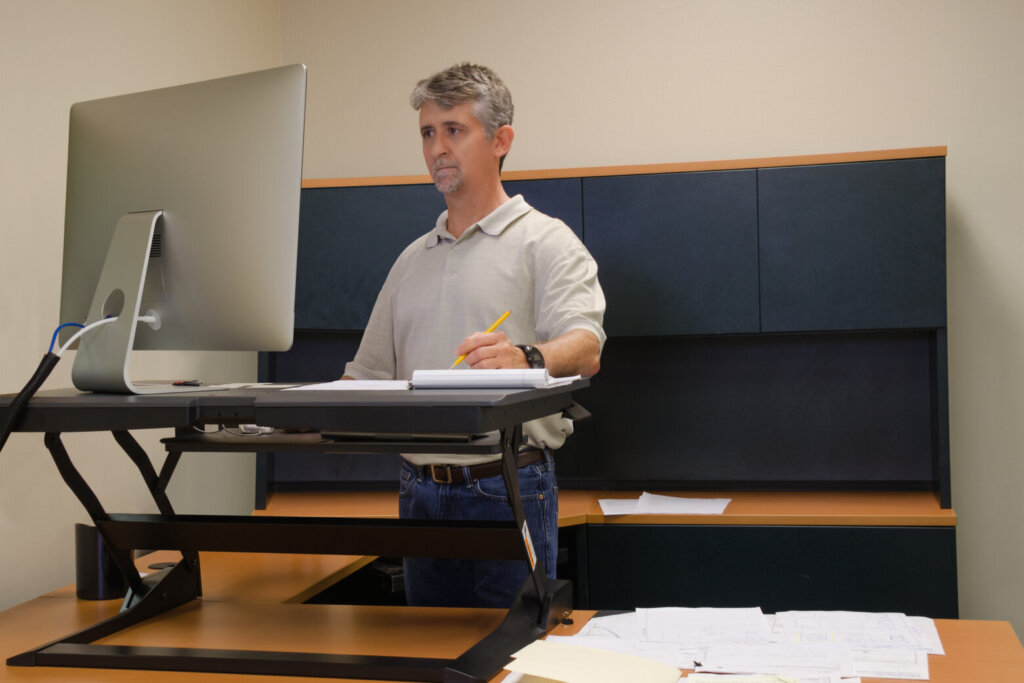 Man using stand up desk in office for good health