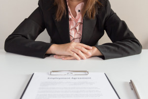 Businesswoman sitting with employment agreement in front of her
