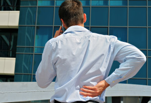 Business man rubbing his painful low back