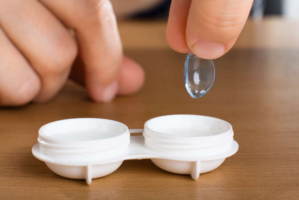 Hand holding contact lens