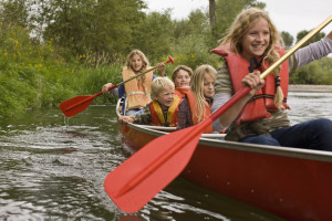 Siblings canoeing on river