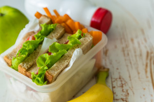 Lunch box with sandwich and fruits