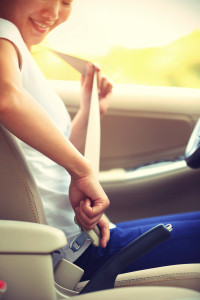 Woman driver buckle up the seat belt before driving car