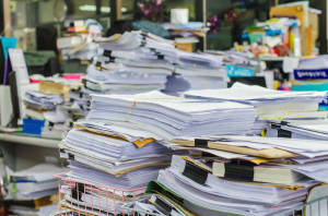 Pile of documents on desk stack up high