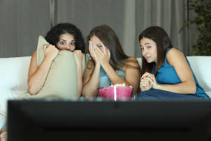 Girls watching a terror movie on tv