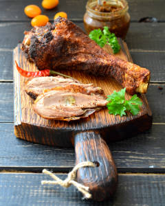 Roast turkey drumstick on a dark wooden table