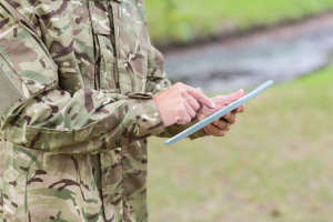 Soldier looking at tablet pc in park