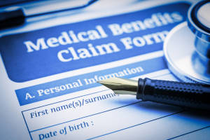 Fountain pen, a stethoscope and a medical benefit claim form.