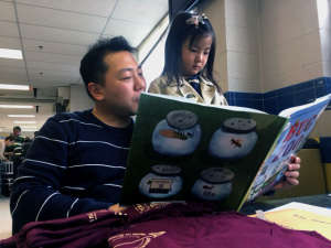 Father and daughter read a book. (WTOP/Jenny Glick)