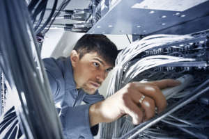 Technician engeneer is checking server's wires in data center