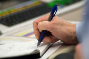 Financial analyst writing notes.