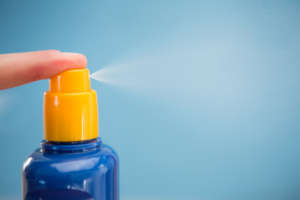 Finger spraying sun tan lotion