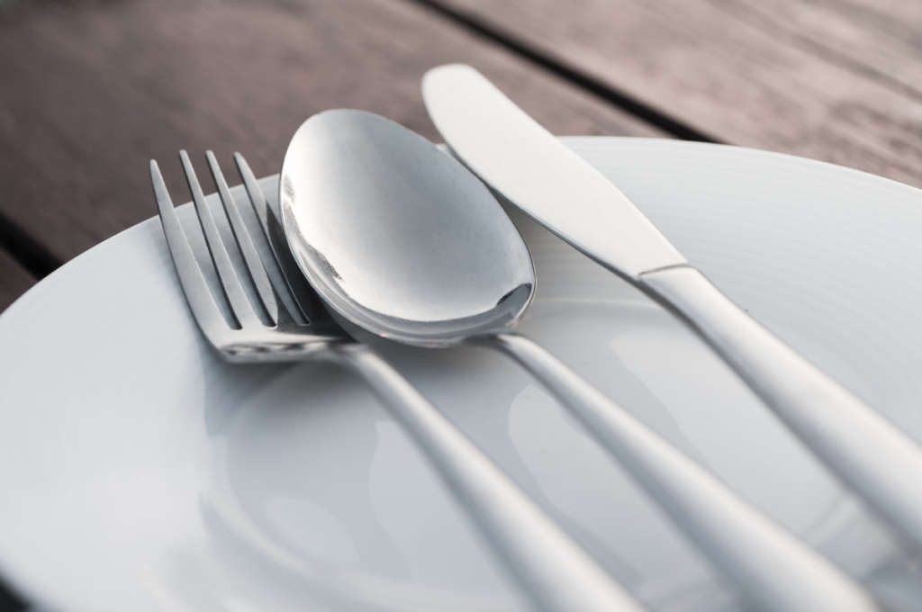 Fork spoon and knife on porcelain dish