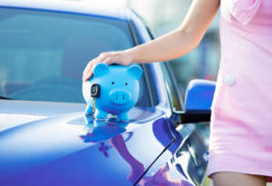 Woman new car, piggy bank, key on hood