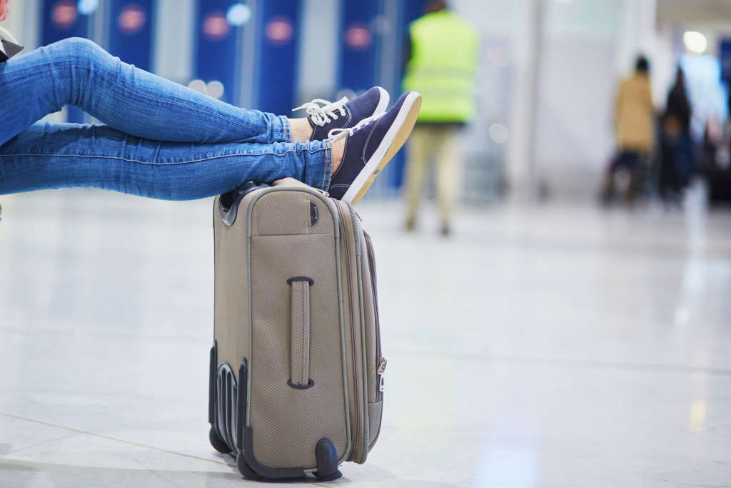 Closeup of woman feet on a suitcase in international airport