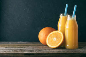 Two glass bottles of fresh orange juice
