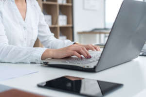 Working with laptop woman writing a blog. Female hands on