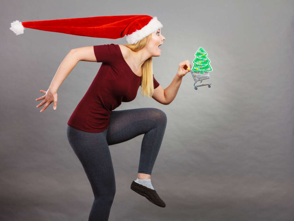 Santa woman holding shopping cart with christmas gifts