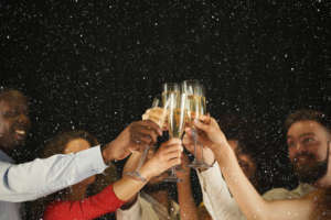 Group of young people celebrating new year with champagne at night club