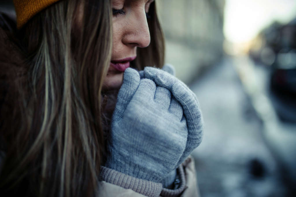 Woman heating her hands in winter