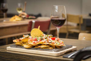 Traditional atmosphere with plate of nachos and glass of red wine