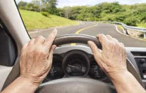 Senior woman driving a car slowly in highway