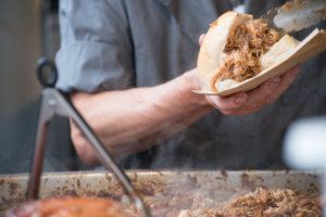 Man preparing sandwich with fresh hot meat from serving tray