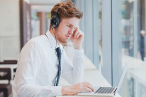 Businessman in headphones working with laptop