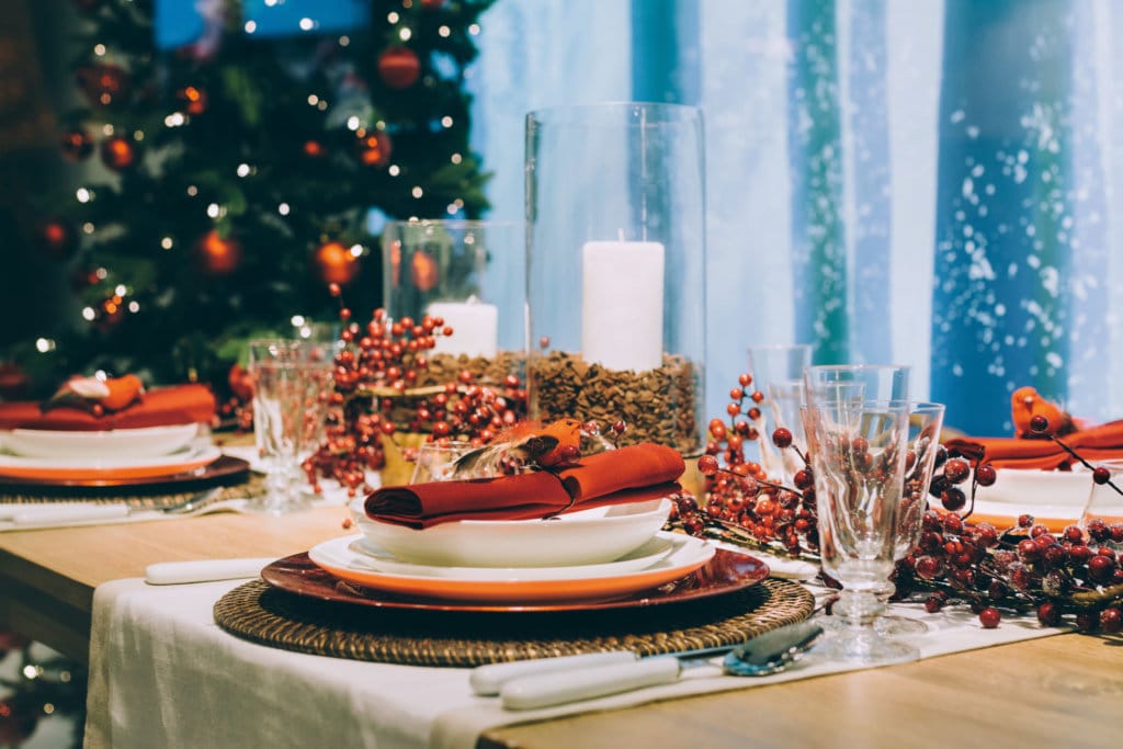 Festive place setting table, next to the Christmas tree