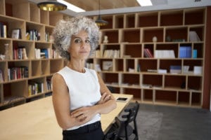 Senior businesswoman standing in boardroom looking to camera