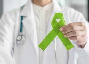 Lime green ribbon in doctorâ??s hand for Lymphoma cancer and mental health awareness, raising support and help patient living with illness