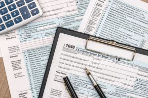 1040 tax form on wooden table with pen and calculator
