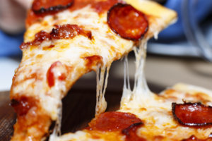Closeup of a piece of pepperoni pizza. Italian pizza.
