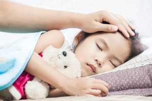 Mother taking care asian child girl while she sleeping in the bed