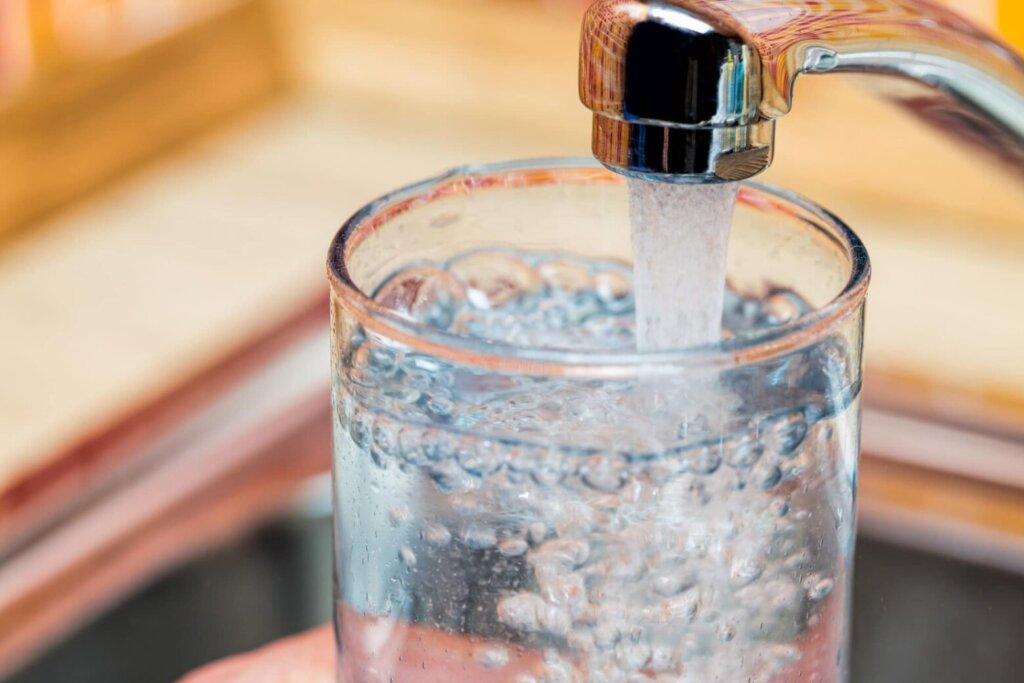 Filling up a glass with drinking water from kitchen tap