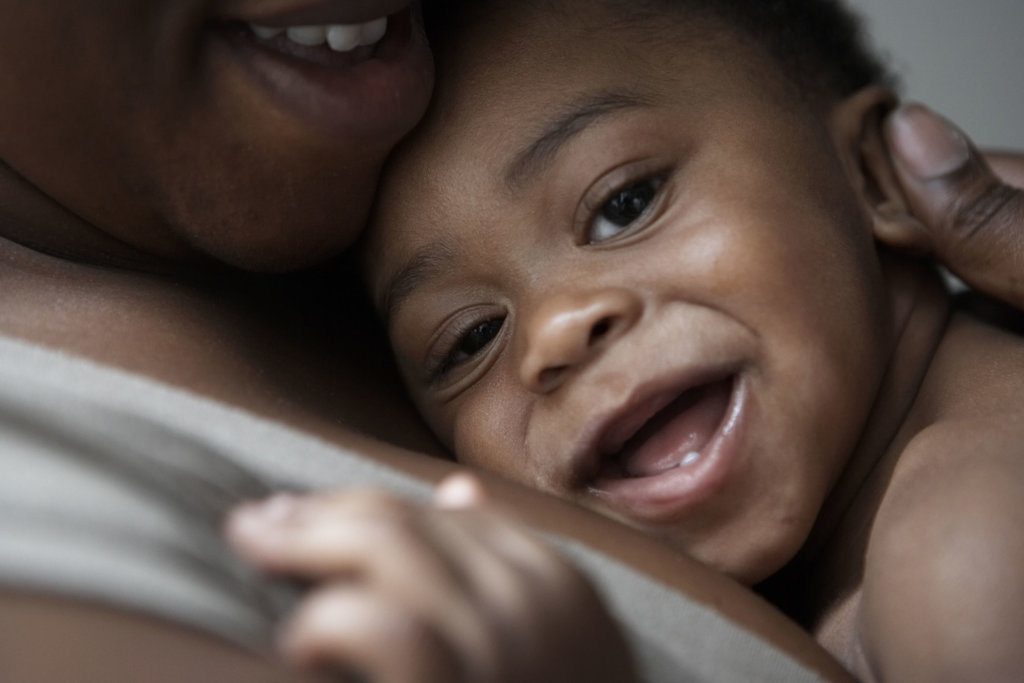 Baby being cuddled by mum smiling