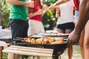 Group of deversity people having barbecue/barbeque party at home, cooking grilled meat/beef for lunch, happy friends party lifestyle concept