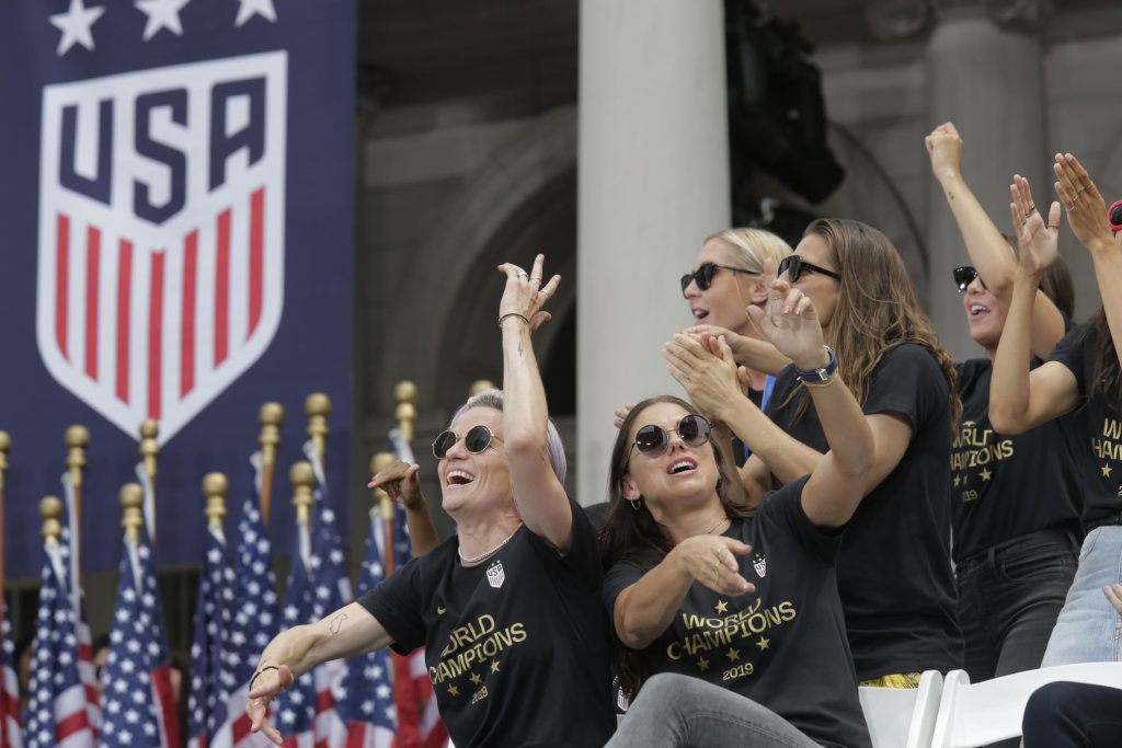 The U.S. women's soccer team, including teammates Megan Rapinoe, left, and Alex Morgan, righ, celebrate at City Hall after a ticker tape parade, Wednesday, July 10, 2019 in New York. The U.S. national team beat the Netherlands 2-0 to capture a record fourth Women's World Cup title. (AP Photo/Seth Wenig)