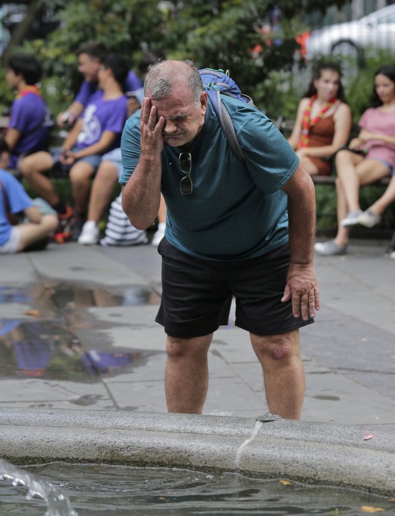 Russ Wilson splashes water on his face from a fountain in New York, Wednesday, July 17, 2019. The heat wave that has been roasting much of the U.S. in recent days is just getting warmed up, with temperatures expected to soar to dangerous levels through the weekend.