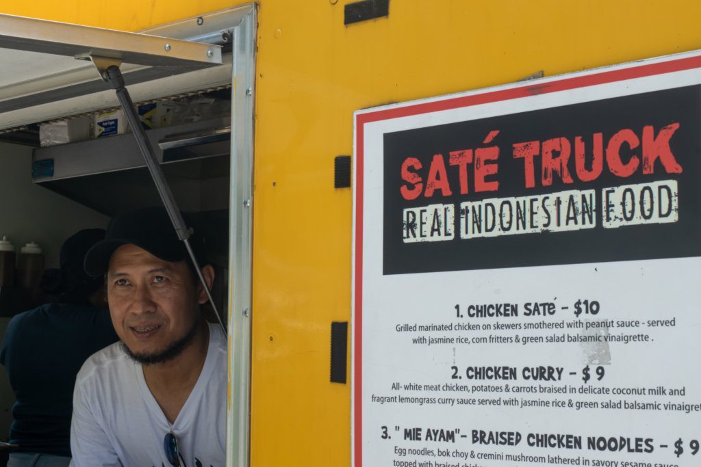 <span style="font-weight: 400;">Sonny Setiantoko leans out the window of his food truck, Sate Truck, in Northwest D.C. </span>