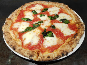 Close up shot of wood fired oven margarita pizza