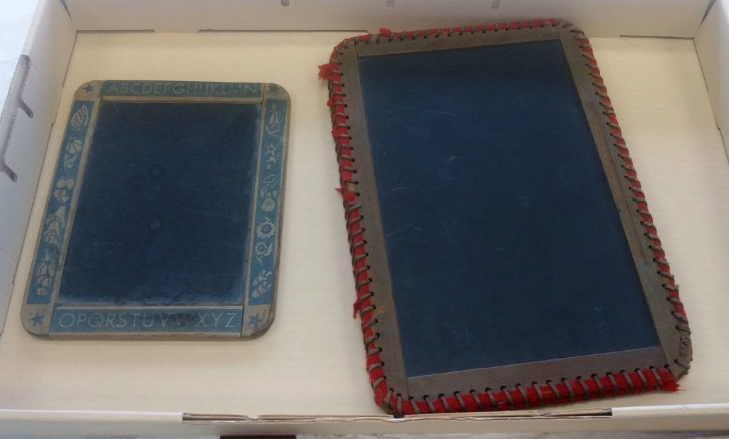 Slates, like the ones above from the 19th century, were often wrapped on the edges to minimize the noise when students open them (like the book slate on the right) or put them down on the desk.
