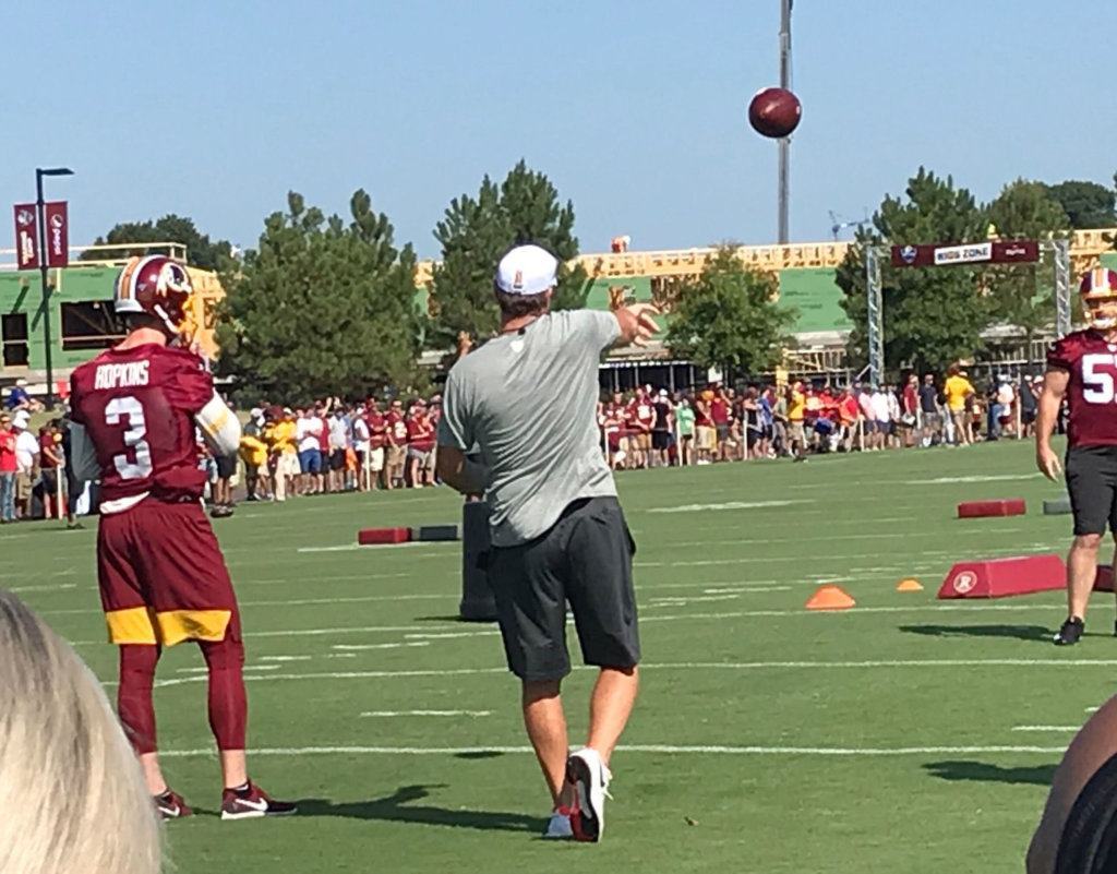 Coach Jay Gruden gets some throws in during the first day of training camp Thursday.