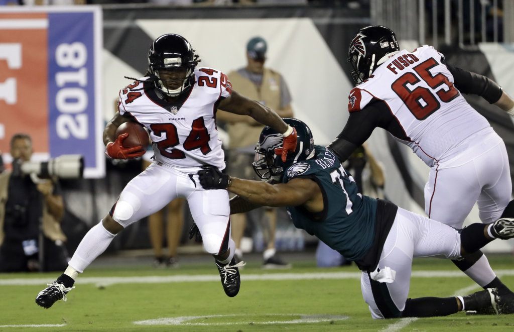 FILe - In this Sept. 6, 2018, file photo, Atlanta Falcons' Devonta Freeman (24) tries to evade Philadelphia Eagles' Michael Bennett (77) during the first half of an NFL football game, in Philadelphia. Freeman, who has missed three straight games with a sore right knee, is expected back this week, just in time to give the Atlanta Falcons a much-needed boost as they prepare to play at Pittsburgh.