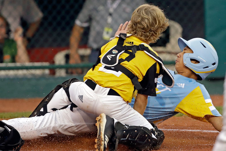 Wailuku, Hawaii's Nakea Kahalehau (9) scores as he slides under the tag of South Riding, Va., catcher Noah Culpepper during the first inning of a baseball game at the Little League World Series in South Williamsport, Pa., Wednesday, Aug. 21, 2019.