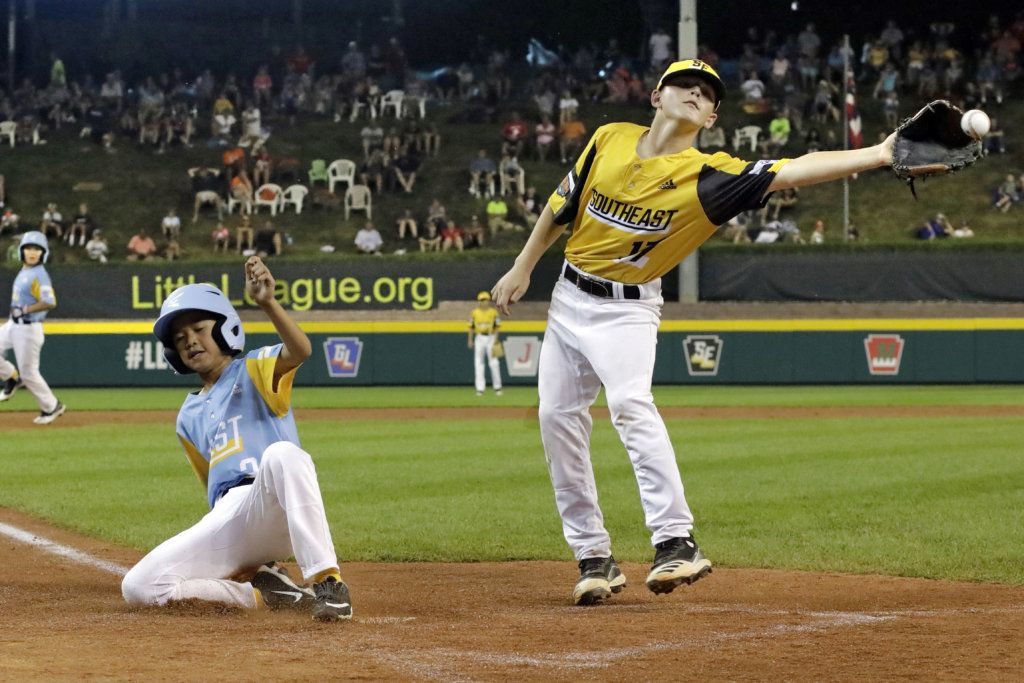 Wailuku, Hawaii's Marley Sebastian, left, scores on a wild pitch as the throw from South Riding, Va., catcher Noah Culpepper gets past pitcher Chase Obstgarten, right, allowing a second run to score during the third inning of a baseball game at the Little League World Series in South Williamsport, Pa., Wednesday, Aug. 21, 2019. Hawaii won 12-9.
