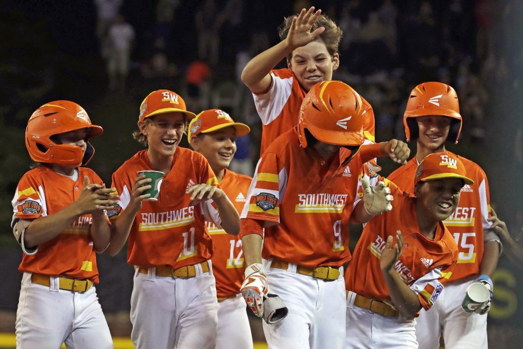 River Ridge, Louisiana's Conner Perrot (9) is surrounded by teammates after driving in the tenth run of the game, and the game winner during the fifth inning of an elimination baseball game against South Riding, Virginia at the Little League World Series tournament in South Williamsport, Pa., Thursday, Aug. 22, 2019. River Ridge, Louisiana won 10-0.