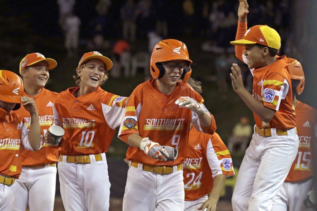 River Ridge, Louisiana's Conner Perrot, center, is surrounded by teammates after driving in the tenth run of the game, and the game winner during the fifth inning of an elimination baseball game against South Riding, Virginia at the Little League World Series tournament in South Williamsport, Pa., Thursday, Aug. 22, 2019. River Ridge, Louisiana won 10-0.